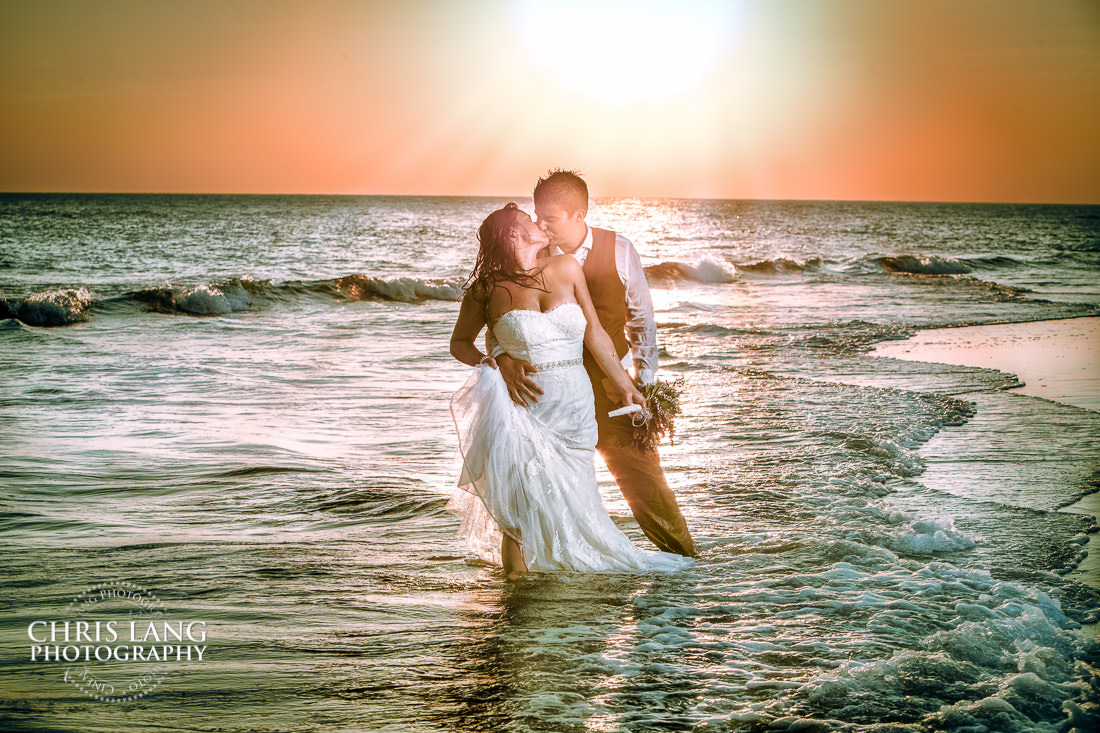 bride and groon in the atlantic ocean near the shoals club - Bald Head Island Wedding Photography