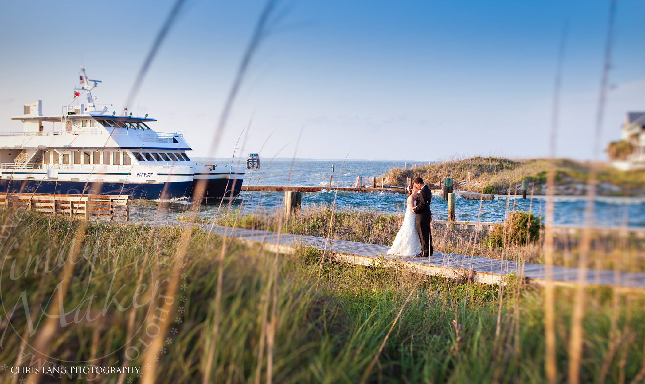 Image of couple wedding couple on the dock with the Bald Head Ferry in the background - Bald Head Island Wedding Photographers