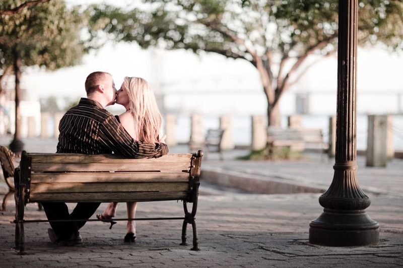 Wilmington-NC-Engagement-Photography-Lifestyle Engagment Session-Picture-Ideas-Inspiration-Couple sitting on park bench kissing