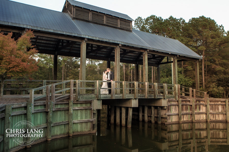TImless wedding picture of couple on the covered bridge at River Landing, Wallace NC - River Landing Wedding Photography