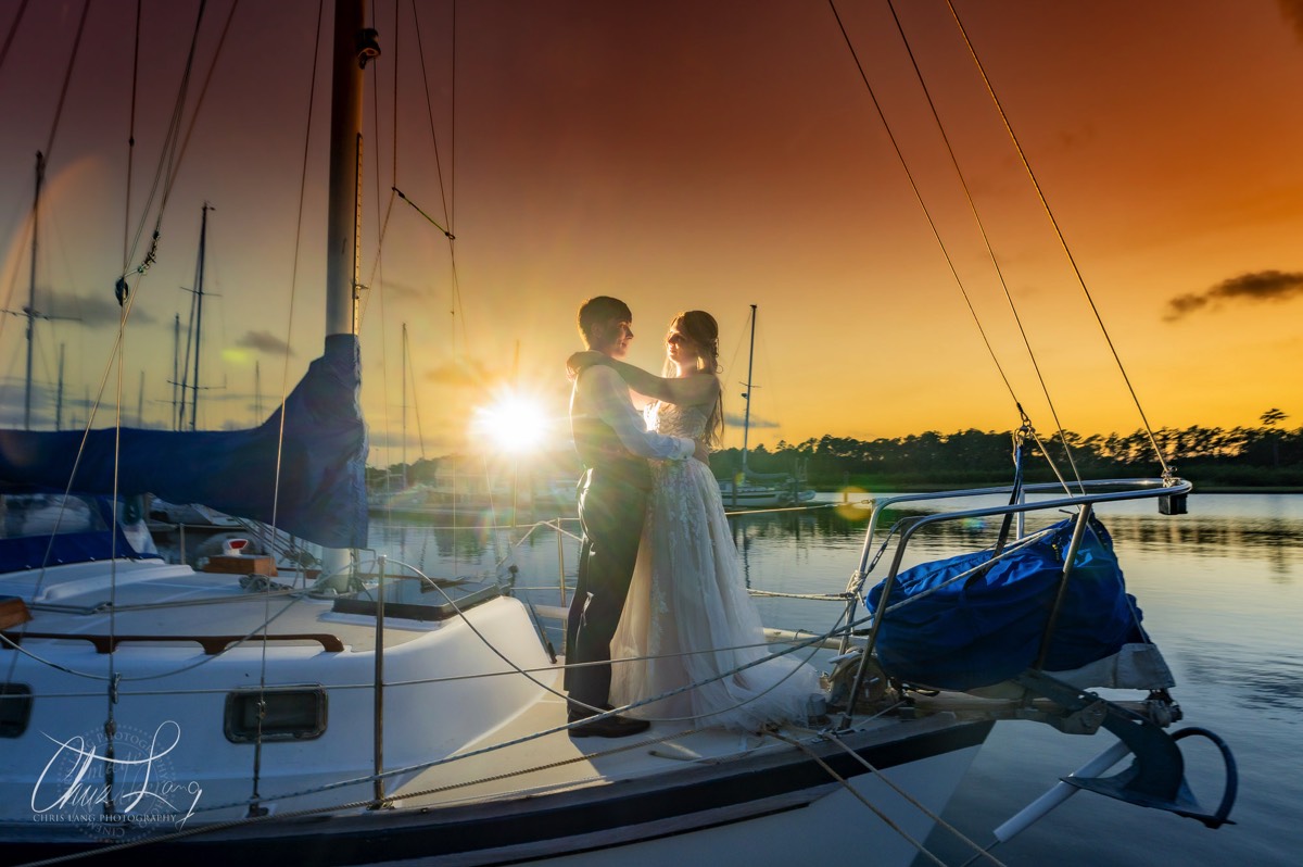 Bride and groom on sail boat - sunset -wilmington nc wedding photographers - creative wedding photo - signature portrats - wedding ideas - bride - groom - wedding dress - chris lang photography