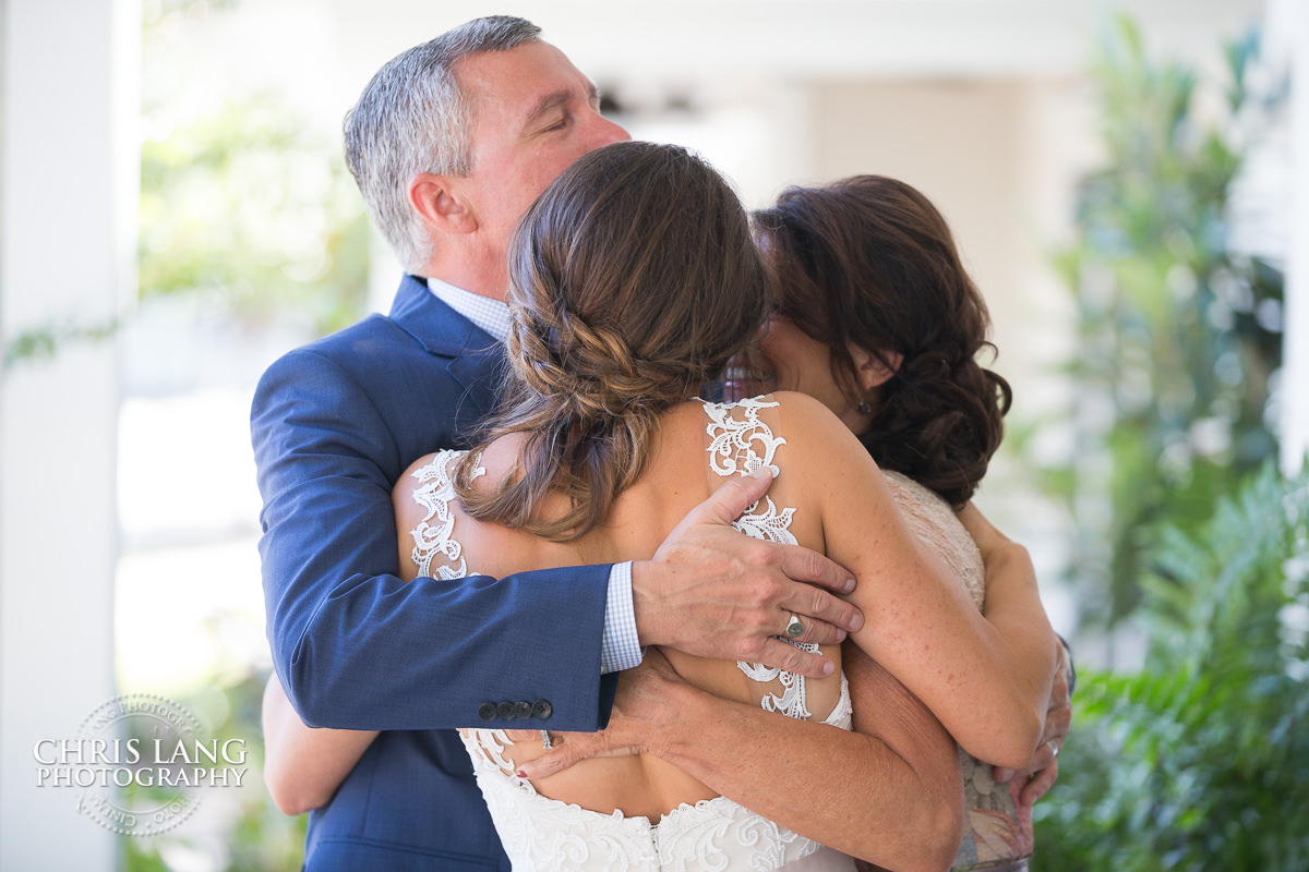 parents of bride hugging thier daughter before the wedding - pre wedding photos - wedding photo ideas - getting ready wedding pictures - bride - groom - wedding dress - wedding detail photos - wilmington nc wedding photography